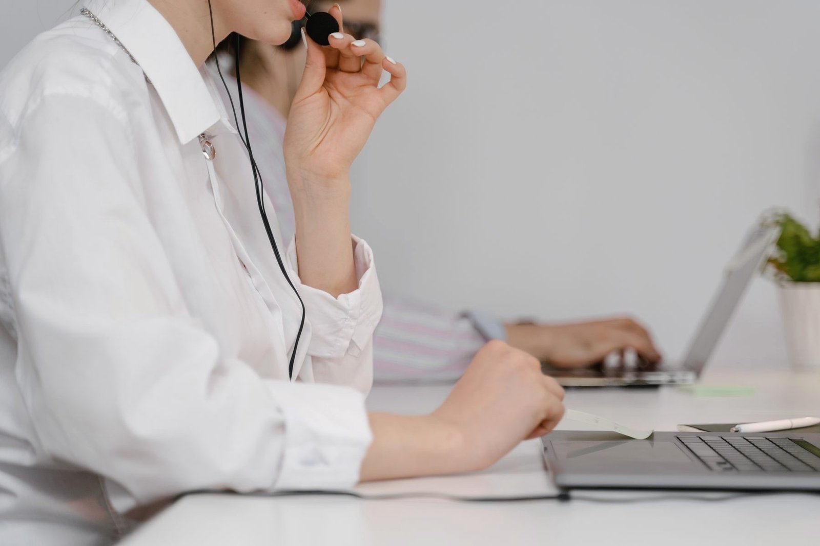 An operator writes while listening to a call through a headset.